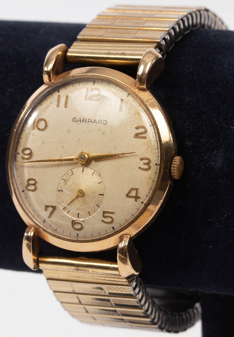 A gentleman's 9ct gold cased wristwatch, the dial inscribed Garrard, with articulated strap,