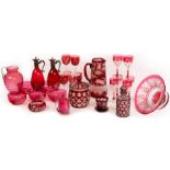 A collection of cranberry and ruby coloured glass, including jugs, bowls,