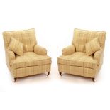 A pair of Howard style deep-seated armchairs, fitted loose cushions on turned front legs,