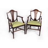 A pair of mahogany shield back armchairs with loose trap seats,