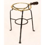 A wrought iron and copper trivet with turned wood handles,