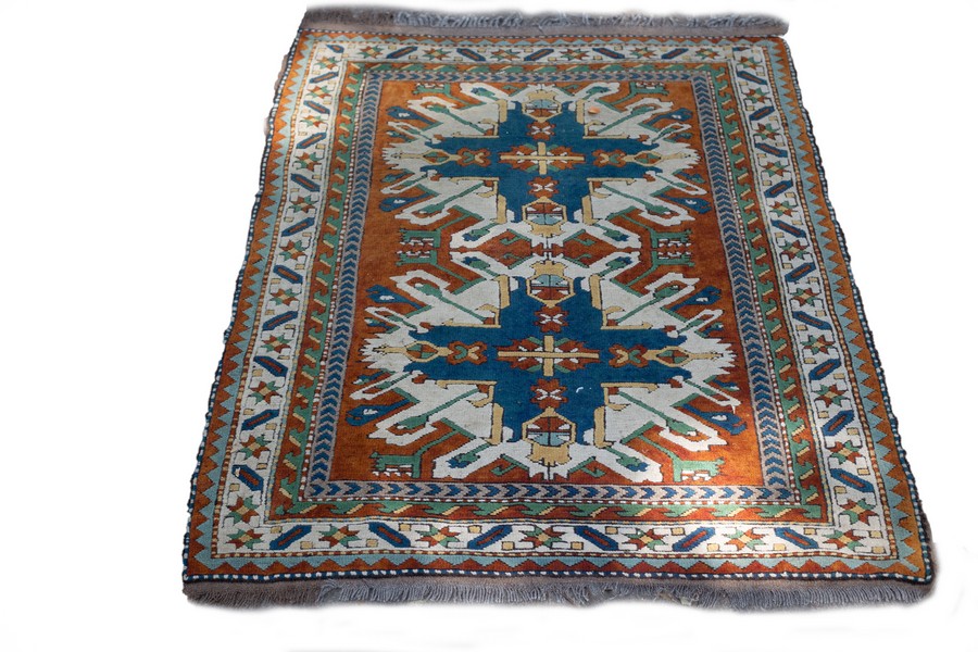 A Hamadan rug with two geometric medallions to the orange ground within a figured border,