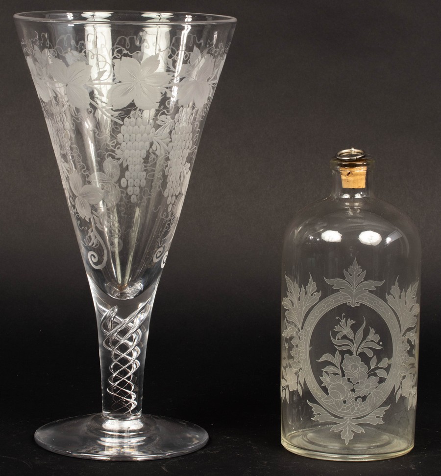 A large glass etched with grapes and vines on an air twist stem,