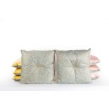 Eight patterned cushions with single central covered button and piped edges,