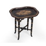 A Chinese export black lacquer tray with gilt decoration, mounted on an ebonised faux bamboo stand,
