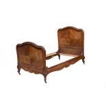 A French walnut bed with moulded arched head and foot boards, on carved cabriole legs,