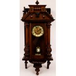 A Vienna type wall clock in a walnut case, fitted an eight-day movement striking on a bell,