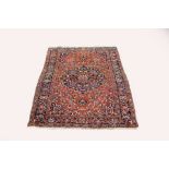 A Hamadan rug with central blue ground medallion within a red ground stylised border,