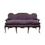 An Italian walnut sofa with carved and moulded frame,