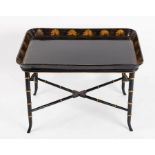 A black lacquered tray mounted on a later ebonised faux bamboo stand,