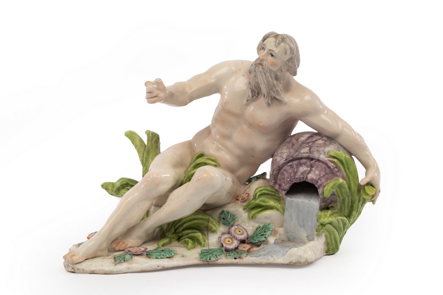 A Chelsea figure of a river God reclining on a rock, circa 1754, encrusted with flowers and foliage,