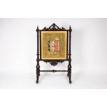 A Victorian armorial fire screen, the needlework panel with the crest of arms of Foljambe,