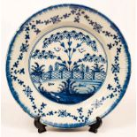A Liverpool Delftware plate, circa 1760, decorated a fenced garden,