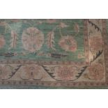 A rug of Persian design, the lime green ground decorated stylised floral designs,