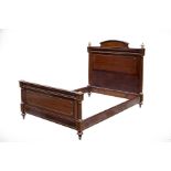 An Empire mahogany parcel gilt bed with turned taper columns to the head and foot boards,