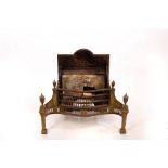 A cast iron brass mounted fire grate with serpentine front and pierced brass skirt,