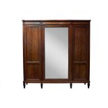A mahogany Empire style wardrobe with breakfront cornice set floral paterae to the frieze and