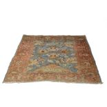 An Ushak Persian rug with field of birds and stylised design on a blue ground,