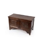 A narrow 18th Century oak coffer, the hinged lid above a double panel front with carved rosettes,