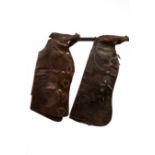 A pair of leather Western chaps decorated with brass studded heart, spade,