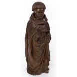 A 19th Century carved limewood figure of a monk holding a scroll,