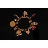 A charm bracelet, the 9ct curb-link bracelet with 15ct gold heart-shaped padlock clasp,