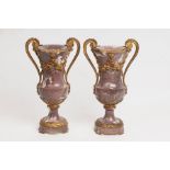 A pair of mauve veined marble vases of Classical form with gilt metal scroll handles and embossed