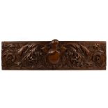 A carved walnut Renaissance style panel with central cartouche surmounted by a helmet and visor,