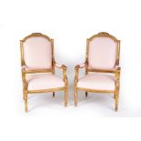 A pair of fauteuils with carved and moulded frames, floral surmounts to the arched backs,