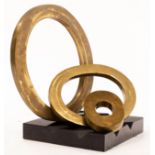 H Simon, a modernist sculpture of three bronzed interchangeable rings on a black ridged base,