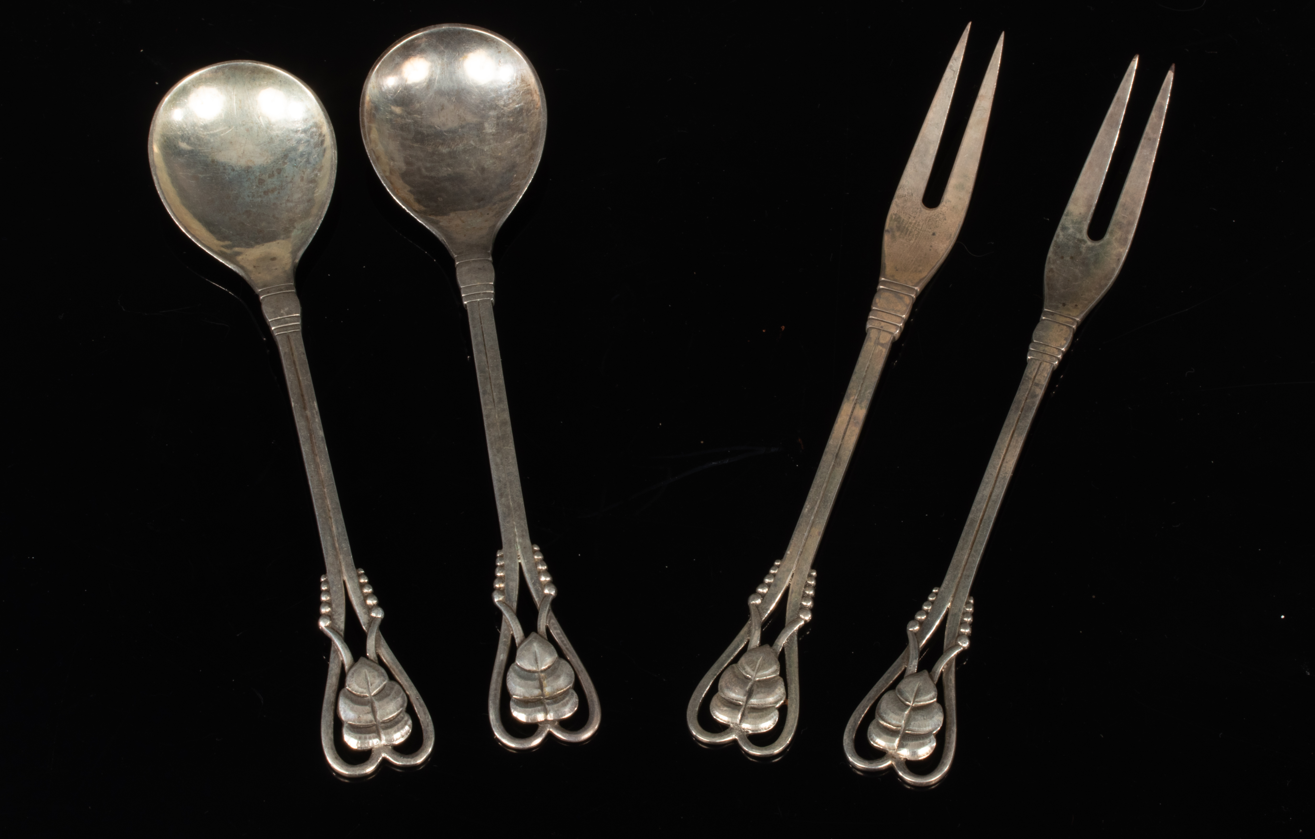 Georg Jensen: A pair of silver spoons and a pair of pickle forks,