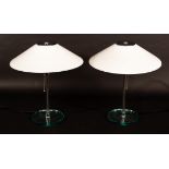 A pair of glass table lights, with opaque glass conical shades and circular bases,