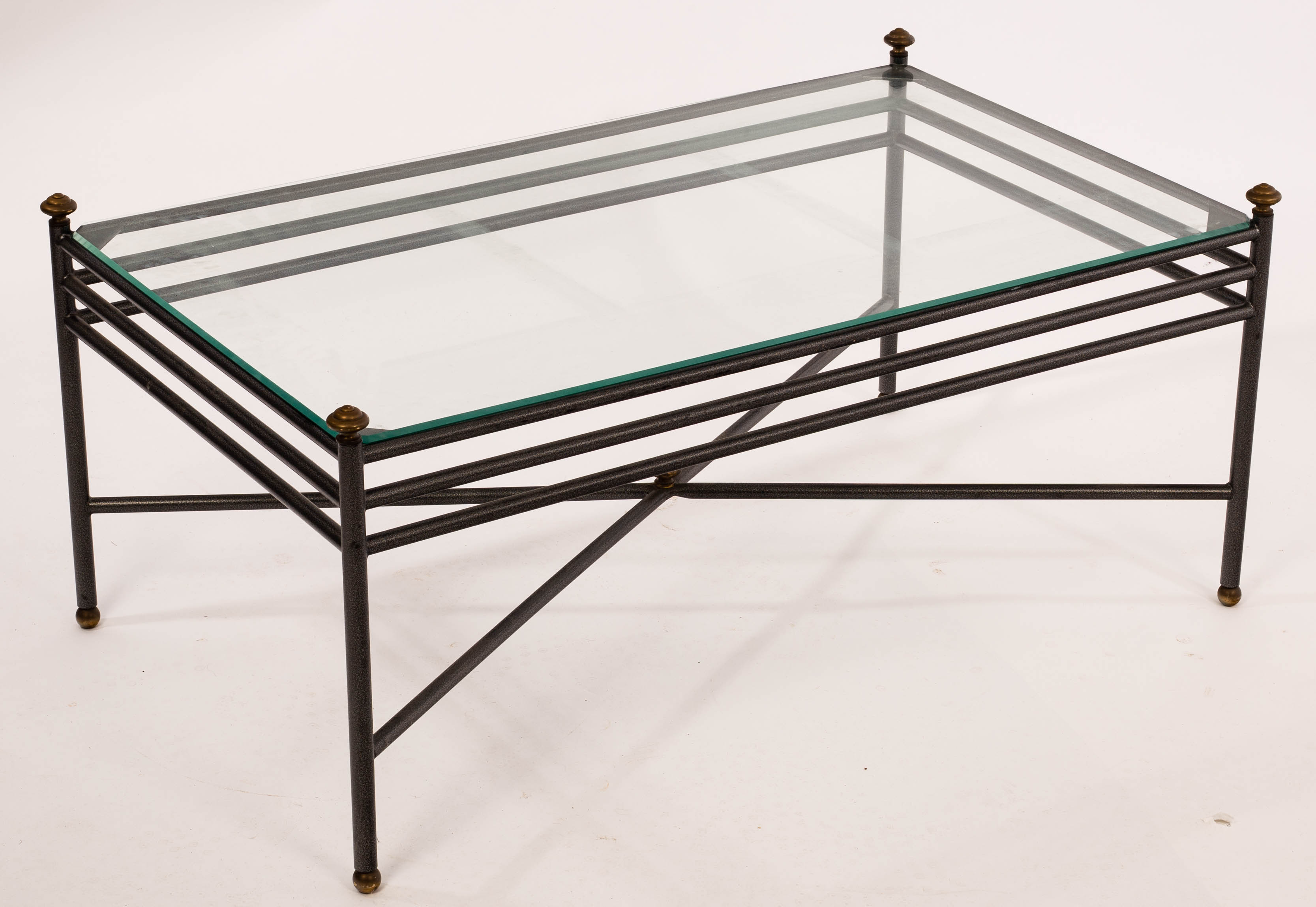 A rectangular wrought iron coffee table with a glass top,