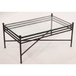 A rectangular wrought iron coffee table with a glass top,