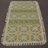 A decorative Casa Pupo rug, in green and white medallion design with tasselled edges,