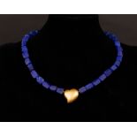 A modern lapis necklace with gold heart centrepiece,