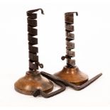 A pair of early 19th Century steel candlesticks with adjusters on turned wood bases,