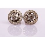 A pair of diamond halo cluster ear studs, the central stone to an outer ring of fourteen stones,