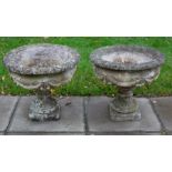 A pair of reconstituted stone garden vases with flanged egg and dart borders,