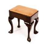 A late 17th/early 18th Century walnut stool with loose trap seat and shaped apron,