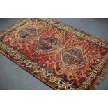 An Eastern rug, the crimson ground with triple pole medallion, 247cm x 160cm and another,