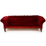 A Victorian Chesterfield sofa, on turned fluted front legs with castors,