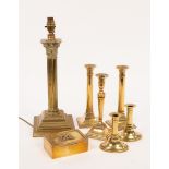 A brass reading lamp with a Corinthian column, three brass candlesticks on square bases,