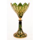 A Victorian green glass vase, cut crenelated rim, on trumpet shape spreading foot,