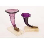 Two early 19th Century amethyst glass cornucopia, on ormolu and white marble plinths,