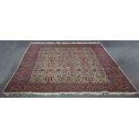 An Eastern rug of aubergine ground decorated all over with flowers within a figured border,
