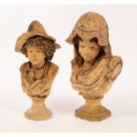 Two white clay busts of children, the boy with curly hair and wearing a hat,