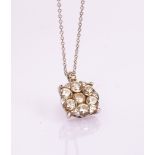 A diamond flowerhead pendant, the seven-stone cluster set in 18ct white gold,