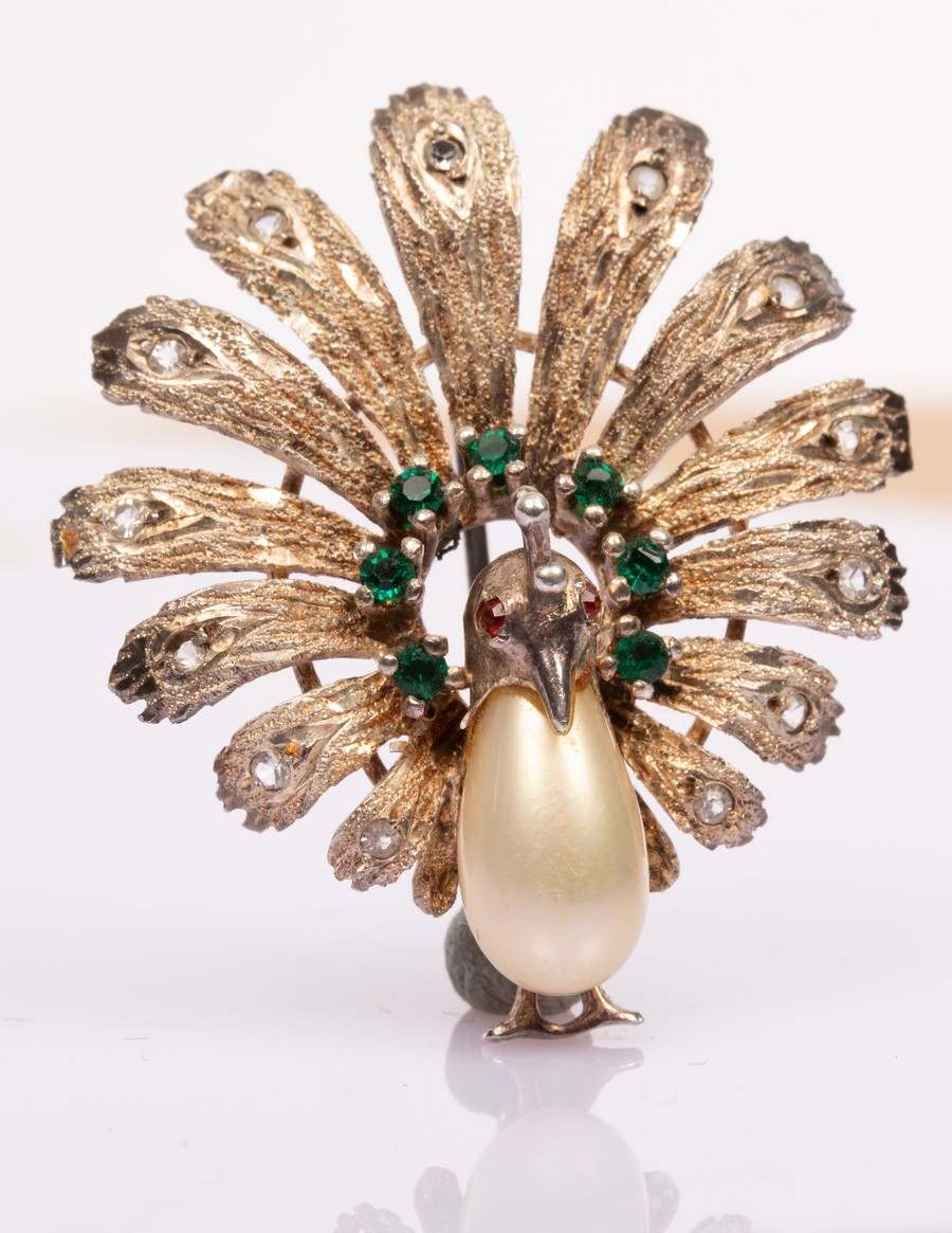 A novelty sterling silver costume brooch modelled as a peacock with a faux pearl body,