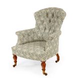 A Howard & Sons button back armchair, on turned front legs with castors,